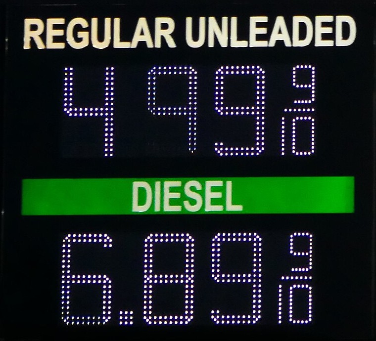 Świetlna tablica cen na stacji: benzyna 4,99 dolara, diesel 6,89 dolara za galon