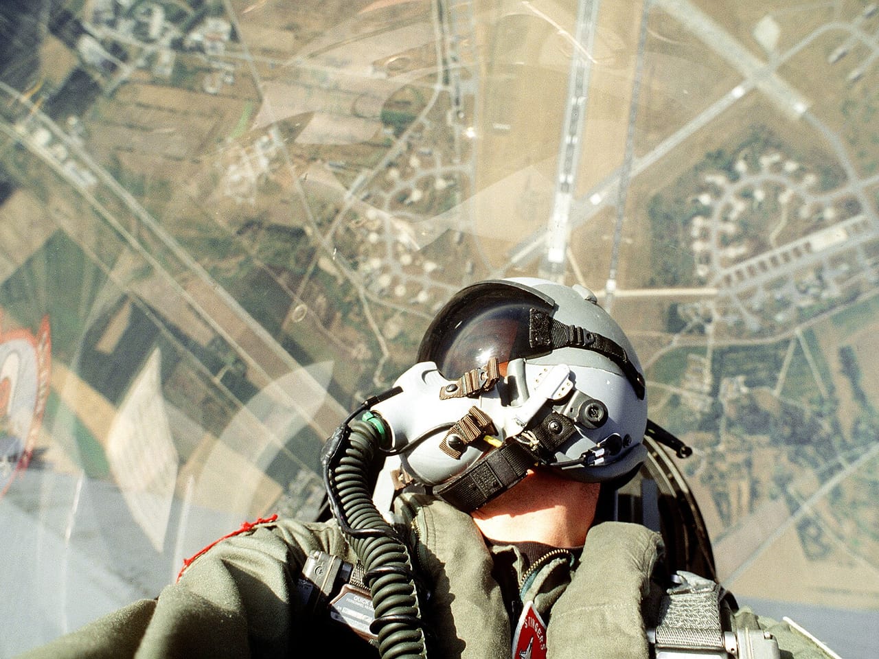 Amerykański F-16 wznosi się pionowo na dopalaczu, w tle powierzchnia ziemi