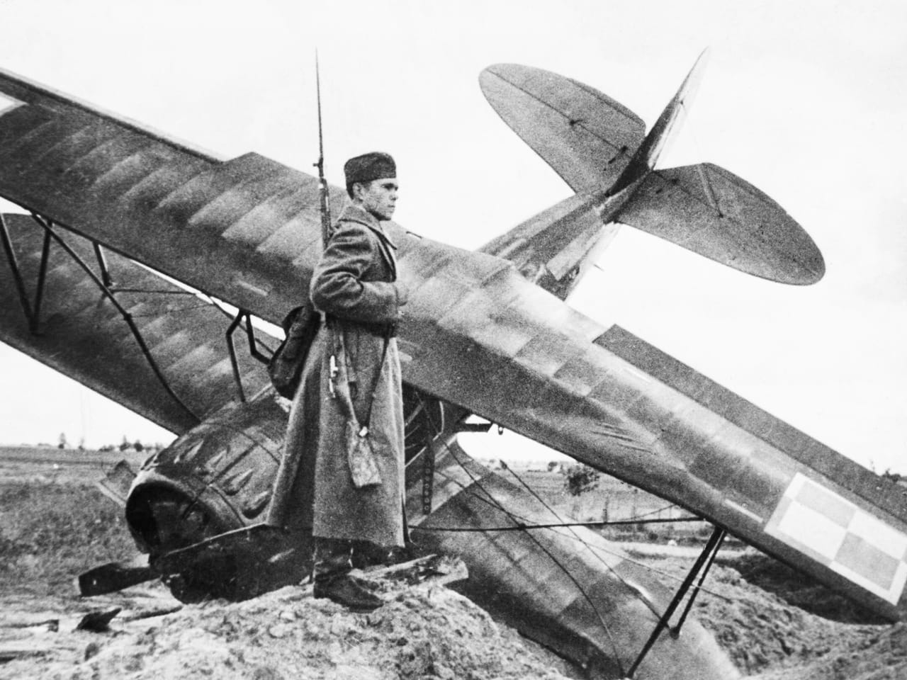 Żołnierz Armii Czerwonej pilnujący rozbitego polskiego samolotu PWS-26 z szachownicami we wrześniu 1939 roku