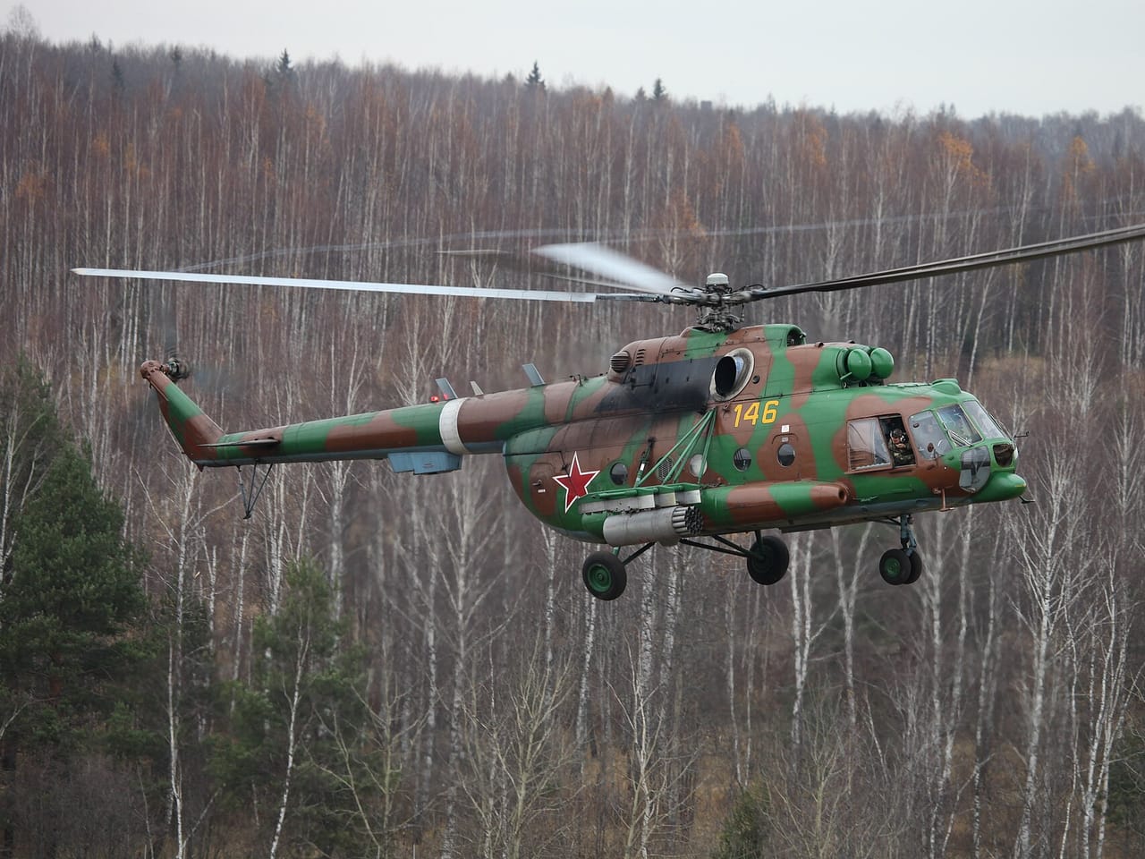 Rosyjski śmigłowiec Mi-8AMTSh w kamuflażu leci nisko nad lasem