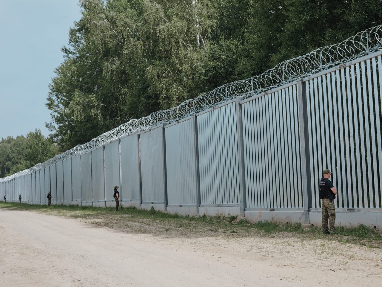 Stalowa zapora na granicy z posterunkami i pasem drogi technicznej