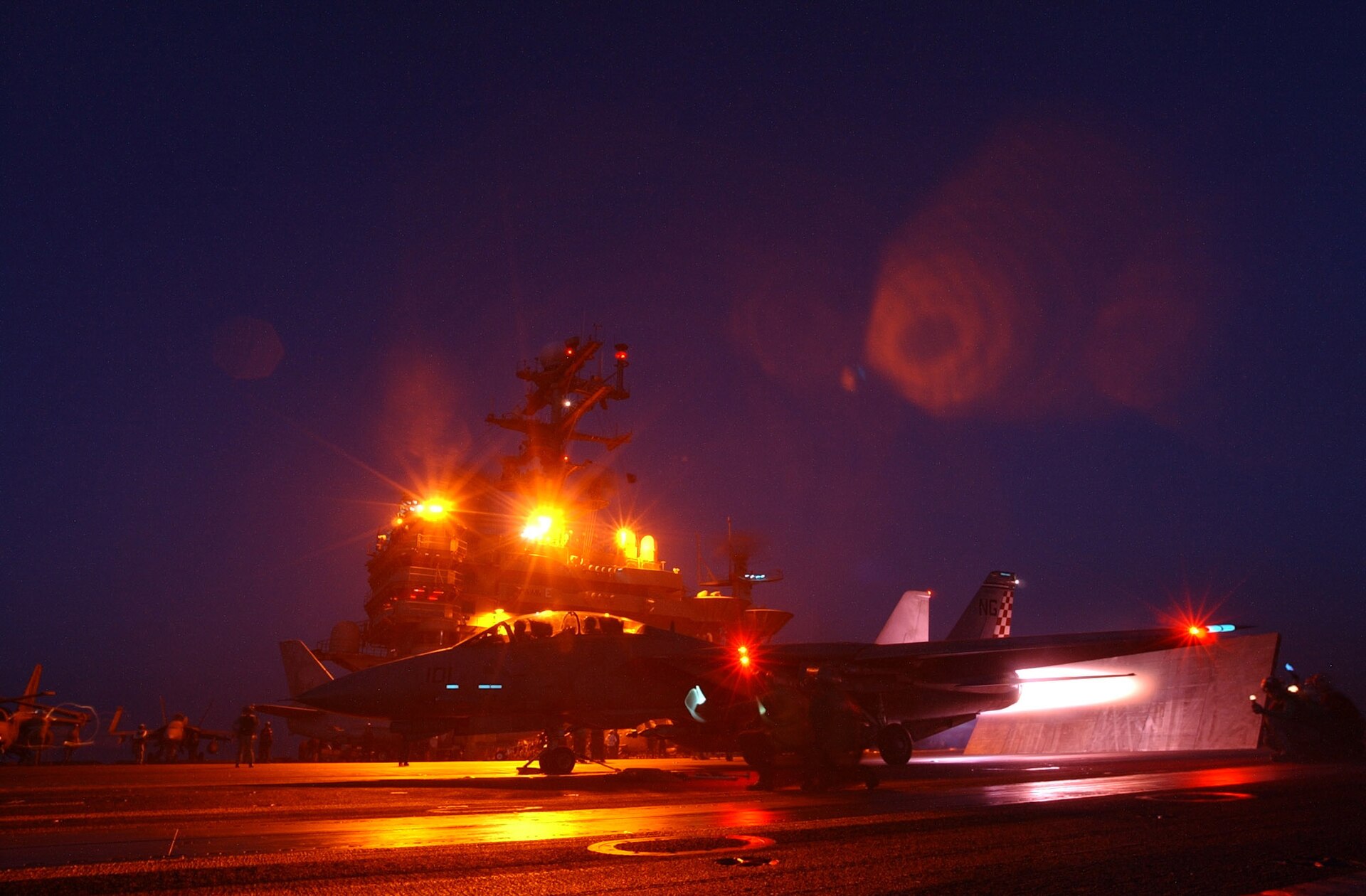 F-14A Tomcat na katapulcie lotniskowca nocą, z włączonym dopalaczem