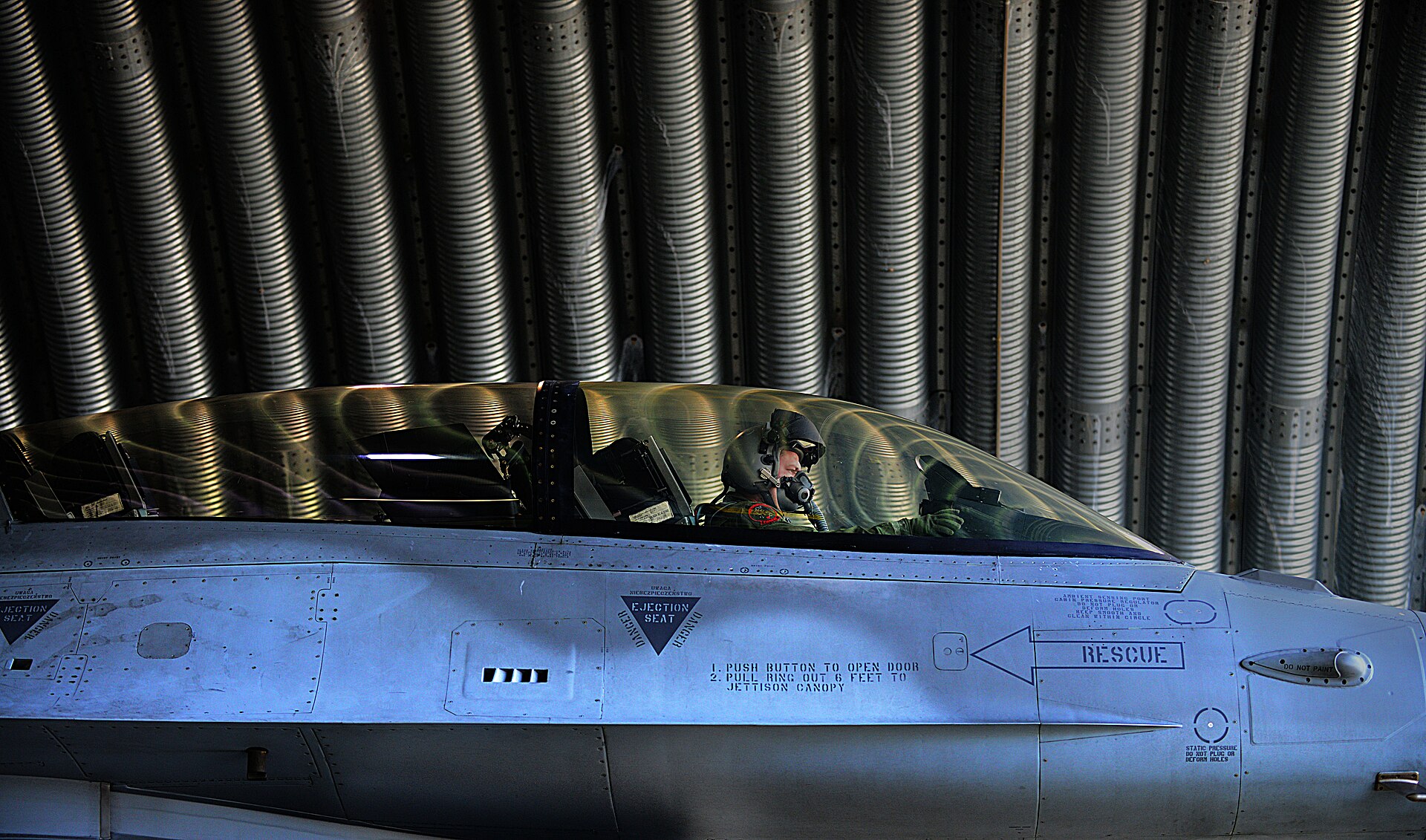 Polski pilot 10 Eskadry Lotnictwa Taktycznego wykołowuje F-16 ze schronu w bazie Łask