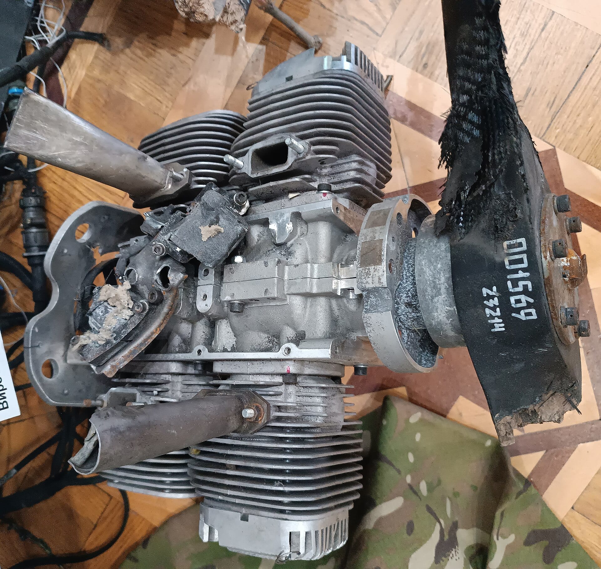 Zniszczony silnik tłokowy MD-550 z drona Shahed-136 leżący na podłodze