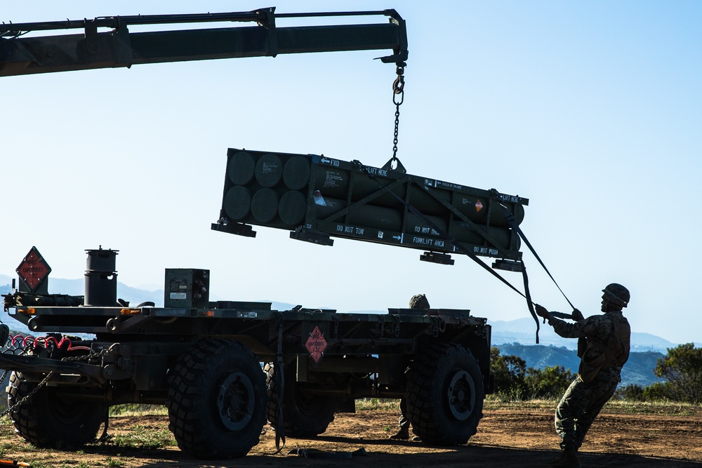 Żołnierz naprowadza podwieszony zasobnik sześciu rakiet GMLRS podczas przeładunku HIMARS
