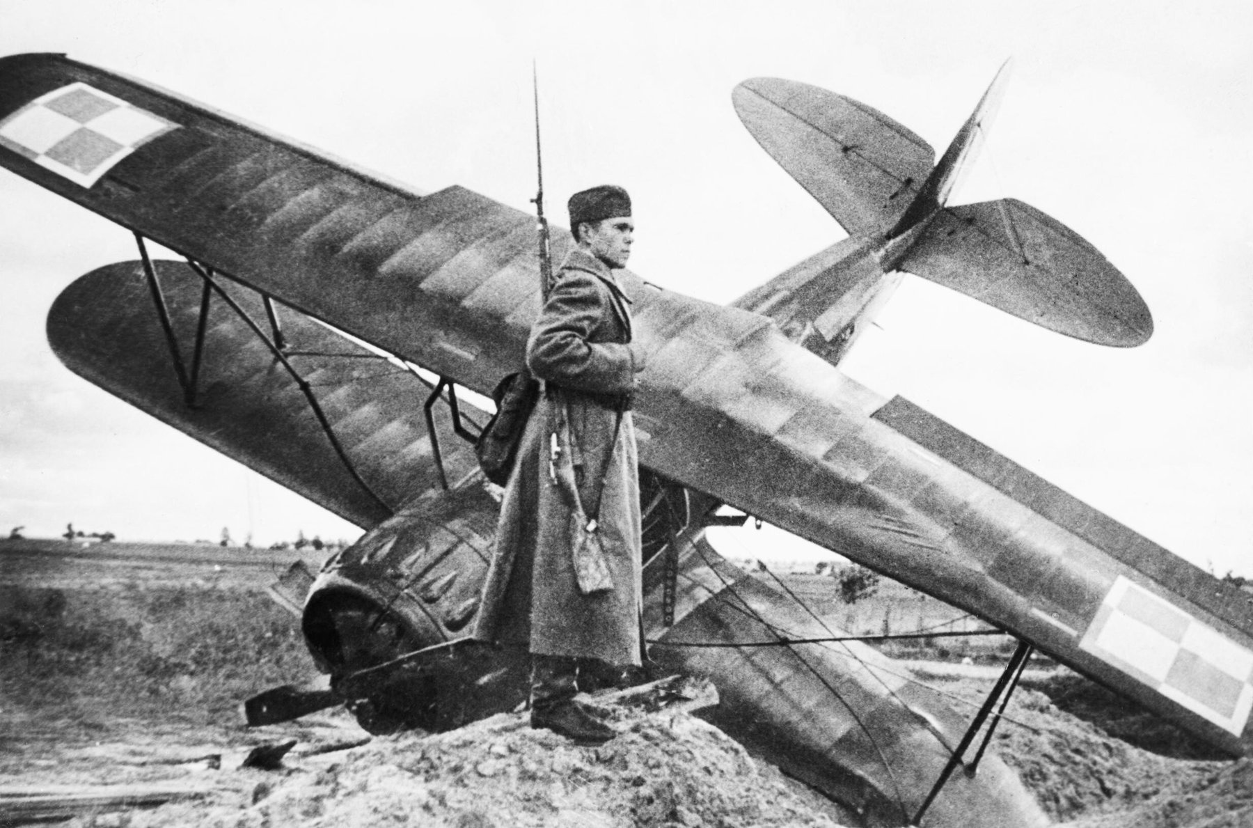 Żołnierz Armii Czerwonej pilnujący rozbitego polskiego samolotu PWS-26 z szachownicami we wrześniu 1939 roku