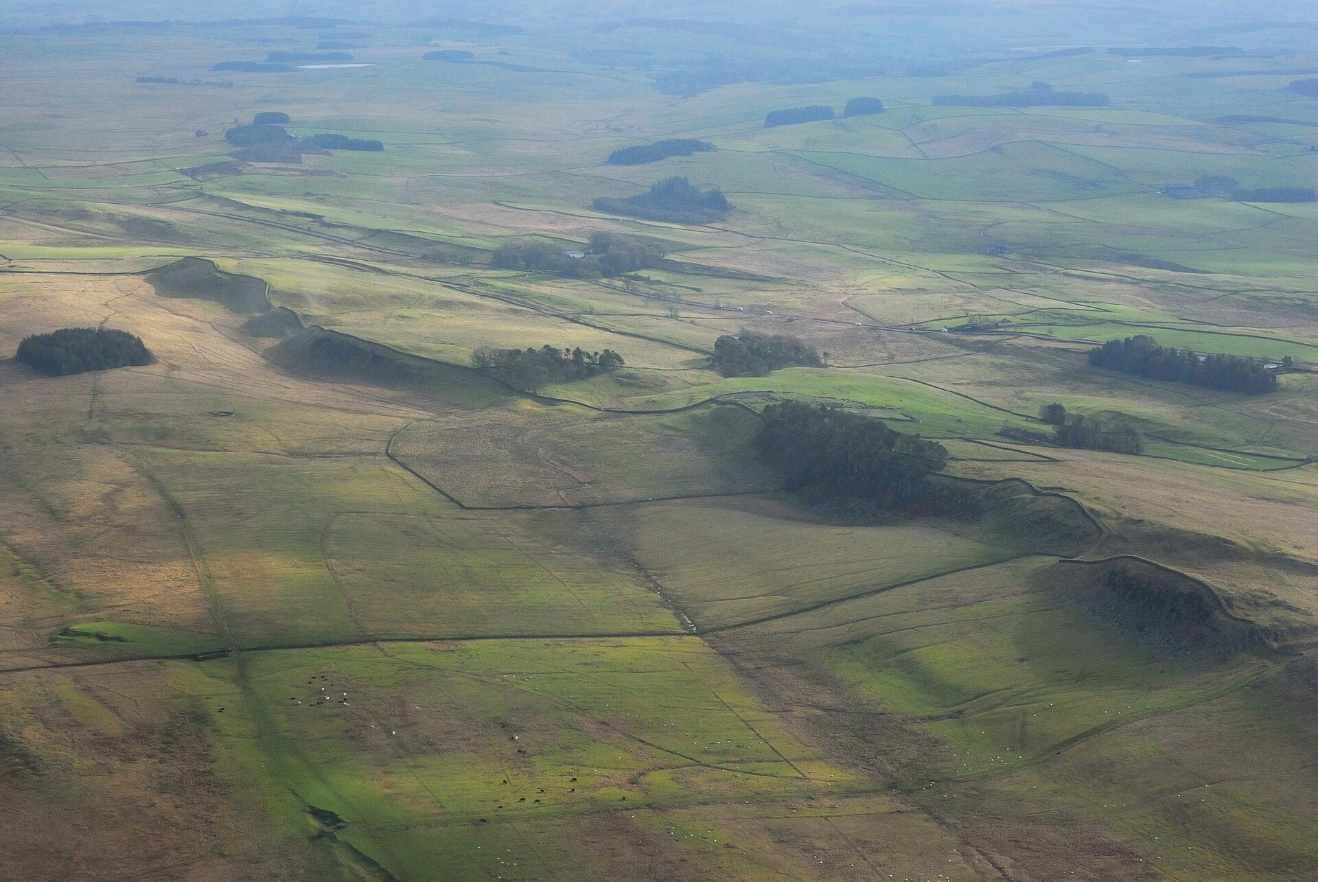 Wał Hadriana i fort Housesteads widziane z lotu ptaka, mur biegnący przez wzgórza
