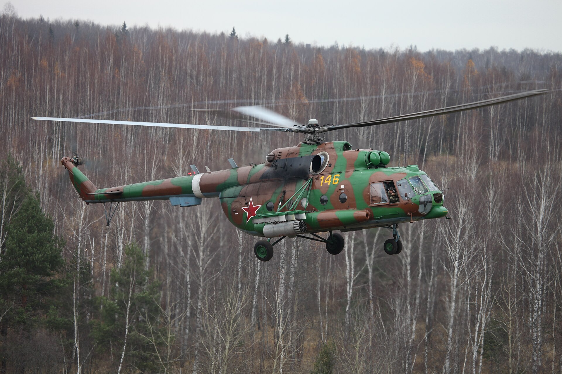 Rosyjski śmigłowiec Mi-8AMTSh w kamuflażu leci nisko nad lasem