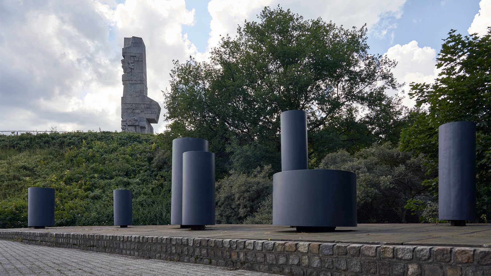 Pomnik Obrońców Wybrzeża widziany spomiędzy kamiennych bloków na Westerplatte